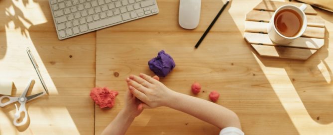 Child with modeling clay at computer