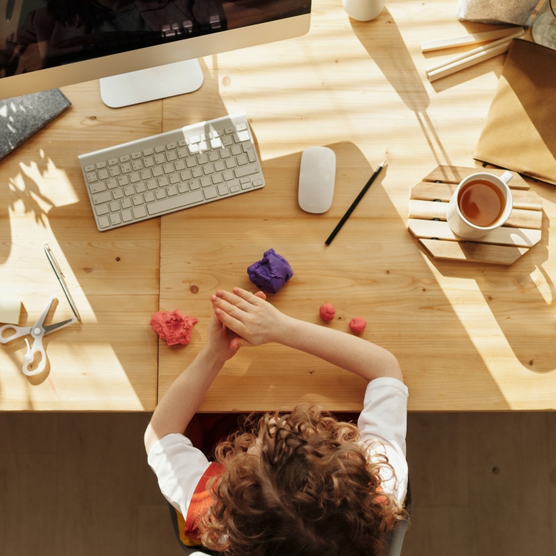 Child with modeling clay at computer