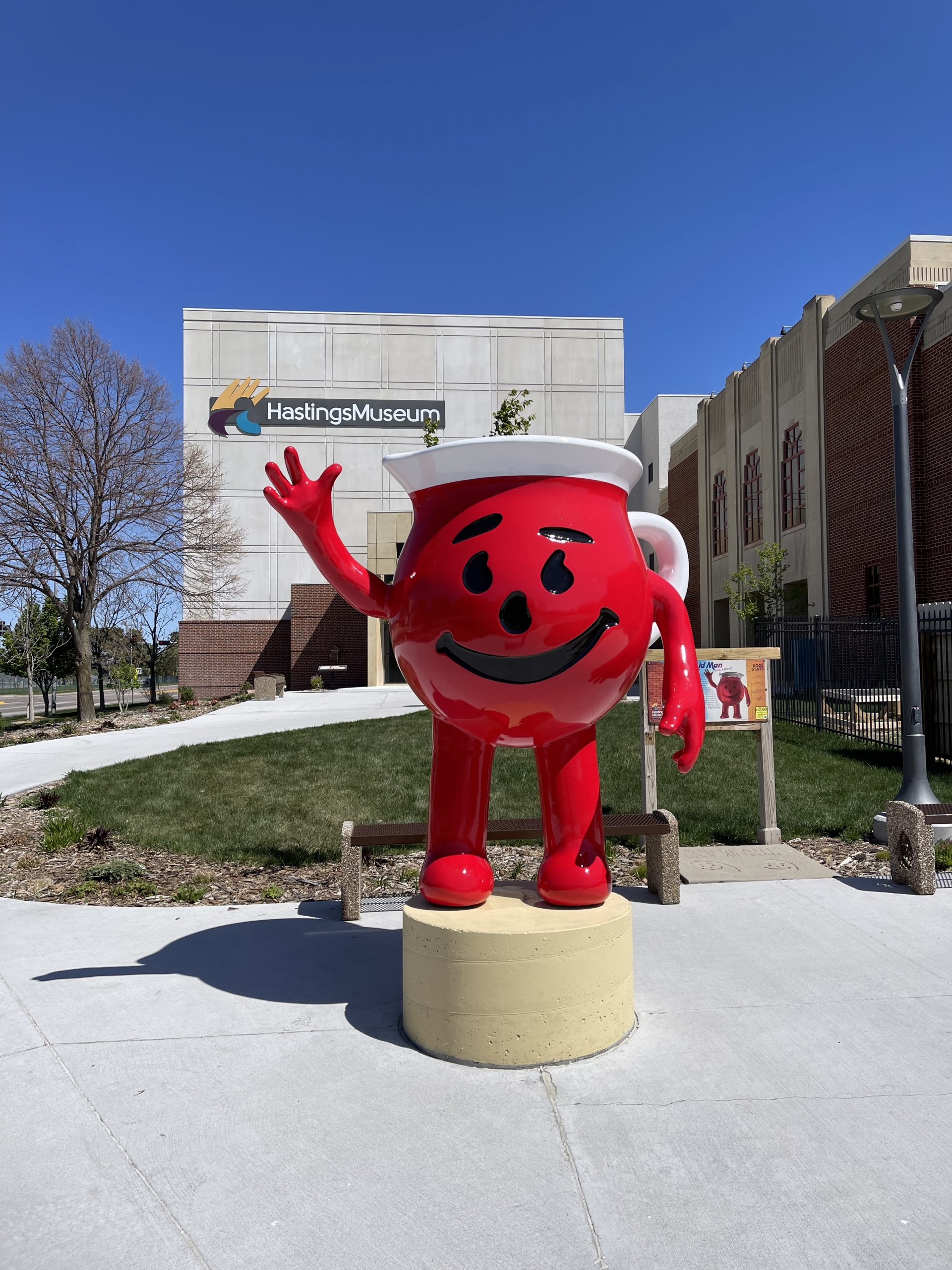 6 foot statue of red Kool-Aid Man with children in front