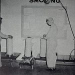 Two ordnance workers weighing 8in/55 caliber bag charges to their proper weight.