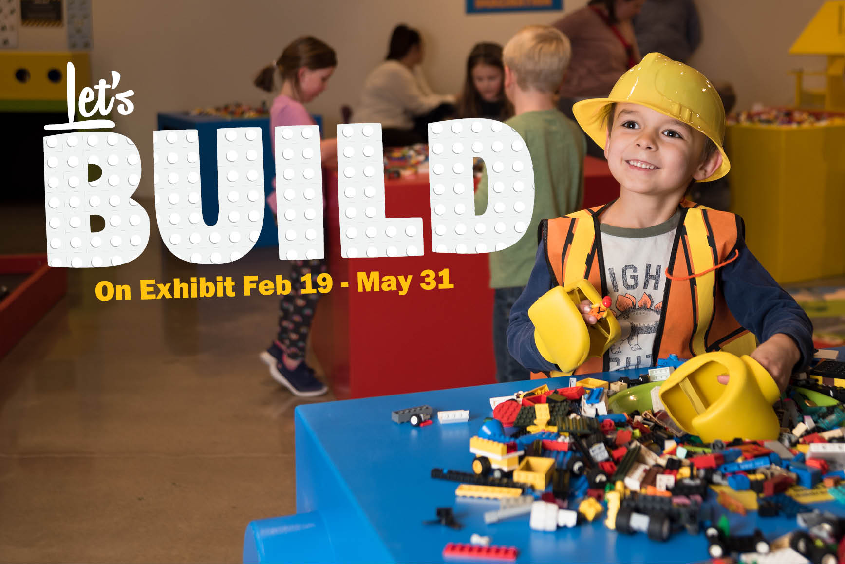 Boy with hard hat playing with LEGOS